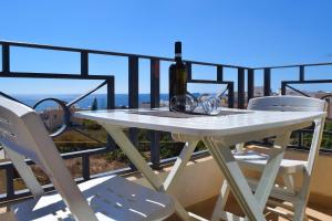 a white table with a bottle of wine on a balcony at Ullswater No. 9 in Marsaskala