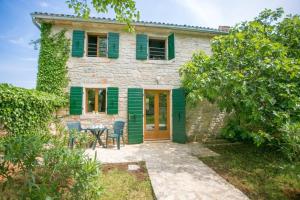 a stone house with green shutters and a patio at Abortolami with Pool and Garden in Selina