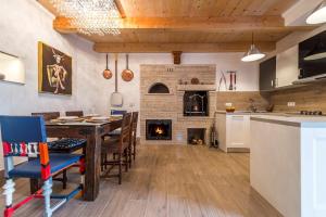 a kitchen and dining room with a table and a fireplace at Villa Art House with Pool in Vižinada