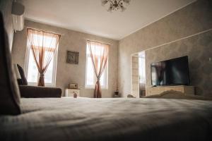 a bedroom with a bed and a flat screen tv at Апартамент Барок in Lovech