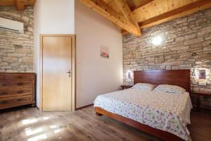 sypialnia z łóżkiem i kamienną ścianą w obiekcie Didova Villa in the Heart of Istria w mieście Jakići +25 zdjęć