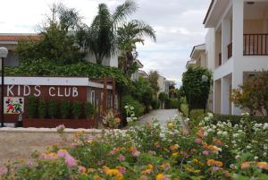 a garden in front of a building with flowers at Aktea Beach Village in Ayia Napa