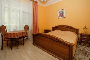 1 dormitorio con cama, mesa y ventana en Lira Hotel, en Saratov