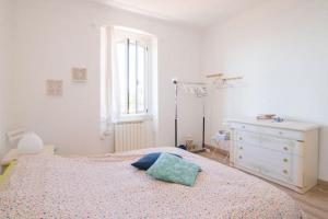 Un dormitorio con una cama con una almohada azul encima. en Amazing Sea view, free parking, near to the centre, en Trieste