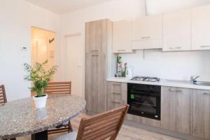 a kitchen with a table with chairs and a counter top at Amazing Sea view, free parking, near to the centre in Trieste