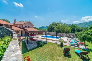 a backyard with a swimming pool and a house at Luxury Stone House Villa Prelec with Private Pool in Drivenik