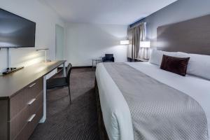 a hotel room with two beds and a television at Heritage Inn Hotel & Convention Centre - Brooks in Brooks