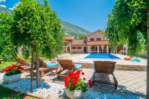 a yard with chairs and a swimming pool at Luxury Stone House Villa Prelec with Private Pool in Drivenik