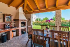 Un patio con chimenea y una mesa y sillas. en Villa Salambati, en Smoljanci