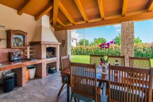 a patio with a fireplace and a table and chairs at Villa Salambati in Smoljanci
