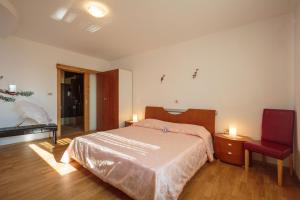 Un dormitorio con una cama y una silla roja. en Villa Salambati, en Smoljanci 28 fotos más