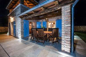 zona de comedor al aire libre con mesa y sillas en Exclusive Villa Tomani with Private Pool en Krmed