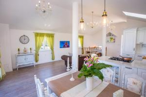 a kitchen and living room with a table with flowers on it at Villa Olive with Pool and Sea View in Ičići