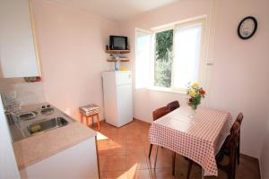 uma pequena cozinha com uma mesa e um lavatório em Labinac Ines, only 300 m from Beach em Poreč