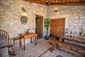 Cette chambre en pierre dispose d'une table et de bancs en bois. dans l'établissement Rustic-Holiday Home Vani with Tavern, near Porec, à Nova Vas