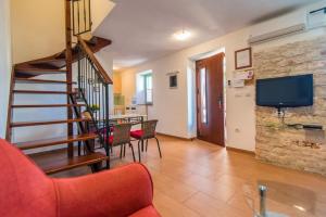 a living room with a staircase and a tv at Casa Gianni Valbandon - Pets friendly in Fondole