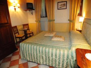 a bedroom with a bed with two pillows on it at La Contrada dei Monti in Orta San Giulio