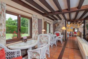 Una habitación con sillas y una mesa y una ventana. en El Molino de Rucandio, en Liérganes