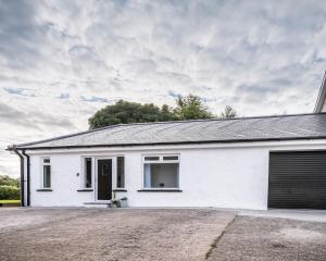 a white house with a driveway in front of it at Riverside Cottage in Carrickfergus