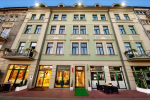 a large building with tables and chairs in front of it at Plaza Boutique Hotel in Kraków