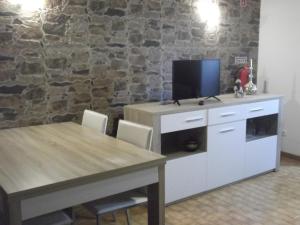 een eetkamer met een tafel en een tv aan de muur bij Casa da Avó in Castelo de Vide