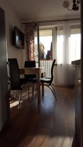 a dining room with a table and chairs and a television at Apartament Pod sanockim zamkiem in Sanok