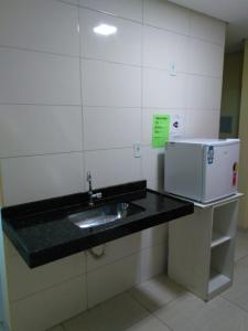 um balcão de cozinha com um lavatório e um micro-ondas em Pousada Elita em Divinópolis