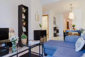 salon z niebieską kanapą i telewizorem w obiekcie Hola Málaga Atarazanas w Maladze