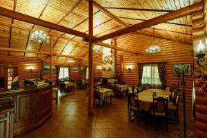 a dining room with tables and chairs in a cabin at Lisova Kazka in Zhdenievo