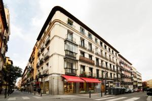 a large white building with red awnings on a street at Chueca Just For You in Madrid
