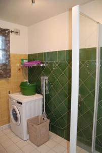 - une salle de bains carrelée de vert avec un lave-linge dans l'établissement Ti ar Rozenn, à Mont-Dol