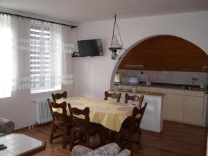 a kitchen and dining room with a table and chairs at Penzion Kuba in Smržovka
