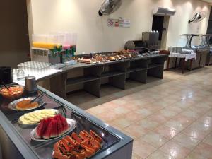 una línea de buffet con muchos tipos diferentes de comida en Hotel Valle Sul, en Registro