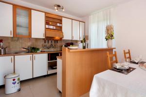 kuchnia z białymi szafkami i stołem z białym blatem w obiekcie Apartment Doris with Private Pool and large Garden w mieście Nova Vas