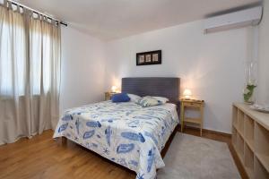 sypialnia z łóżkiem z niebiesko-białym kocem w obiekcie Apartment Doris with Private Pool and large Garden w mieście Nova Vas +36 zdjęć