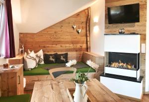 a living room with a fireplace and a couch at Alpendorf Auszeit in Sankt Johann im Pongau