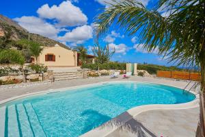 a swimming pool in front of a house at Villa Ninetta in Scopello