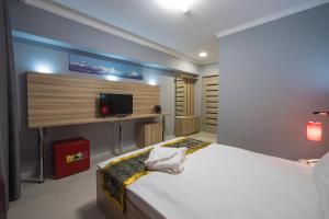ASIA Hotel في ألماتي: غرفة نوم بسرير وتلفزيون على جدار