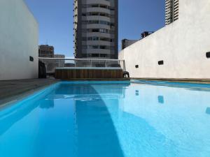 a swimming pool with blue water in a building at City Park Buenos Aires Suite in Buenos Aires