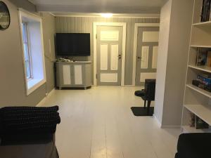 una sala de estar vacía con TV y puerta en Rodal Lodge, en Valsøybotn