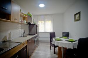 a kitchen with a table and a small table and chairs at Park Apartman in Arandelovac