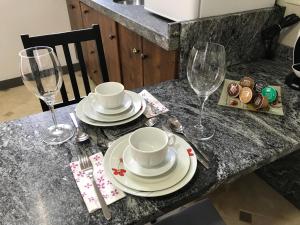 - une table avec des assiettes et des verres à vin dans l'établissement Loft Arco del Cristo., à Cáceres