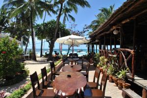 a table and chairs with an umbrella and the beach at Surfside Boracay Resort in Boracay