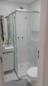 a bathroom with a shower and a toilet and a sink at Pé na areia em Boiçucanga condominio Aquamarine - perto de Maresias e Camburi in Boicucanga
