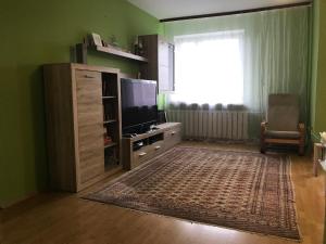 a living room with a television and a large window at Lokum u Joanny in Nowy Łupków
