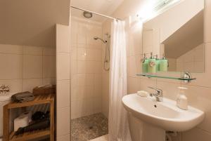 a white bathroom with a sink and a shower at Cliff Edge by the Sea in Paihia