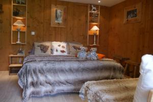 two teddy bears sitting on a bed in a bedroom at Chalet la Colombière in Sainte-Agnès