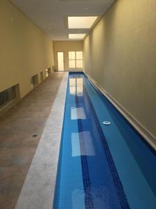 a large swimming pool in a building with blue tiles at Amora Três in São Paulo