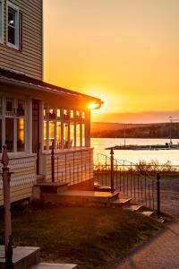 a house with a porch with the sunset in the background at Manoir D'Orsennens in Lac-Mégantic