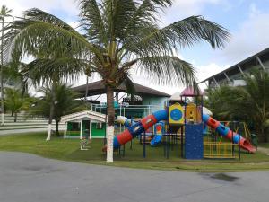 einen Spielplatz in einem Park neben einer Palme in der Unterkunft ANCORAR FLAT RESORT f6203 in Porto De Galinhas